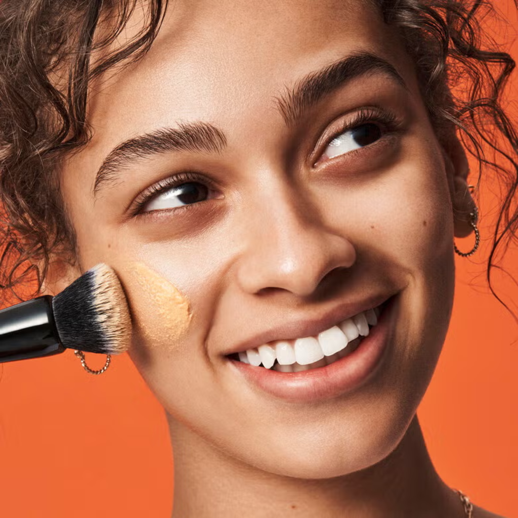 Model brengt e.l.f. C-Brightening Putty Primer aan voor een stralende make-upbasis.