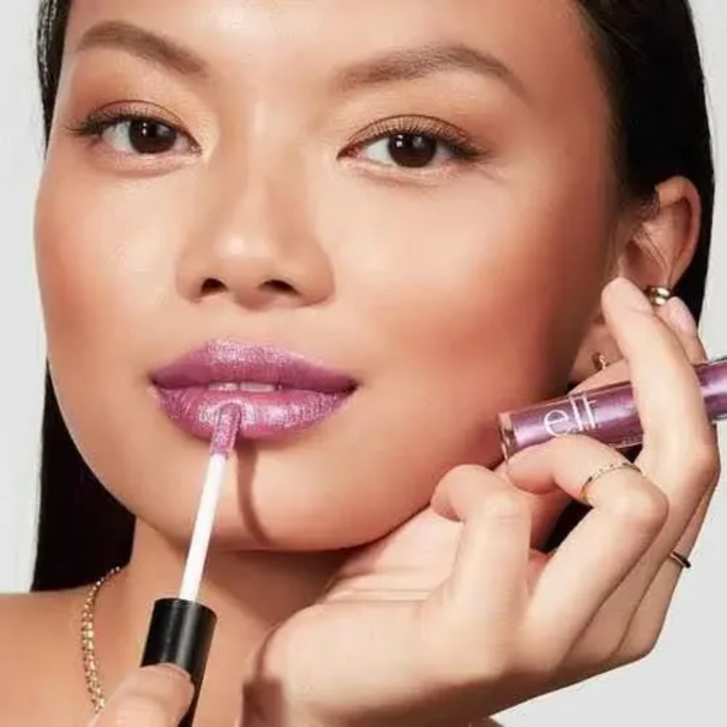 Model brengt e.l.f. Prismatic Lip Gloss Amethyst aan voor een glanzende liplook.